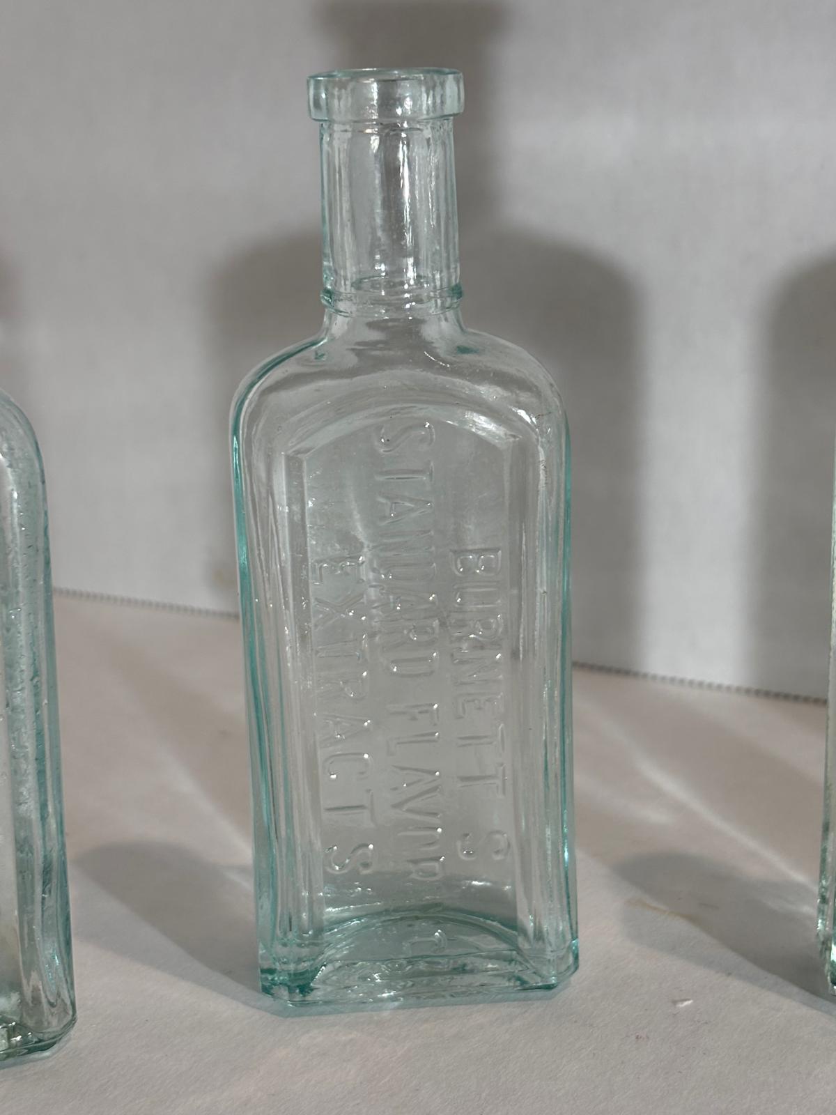 Group of Six Burnett’s Standard Flavoring Extract Bottles, Boston, Late 19th Century