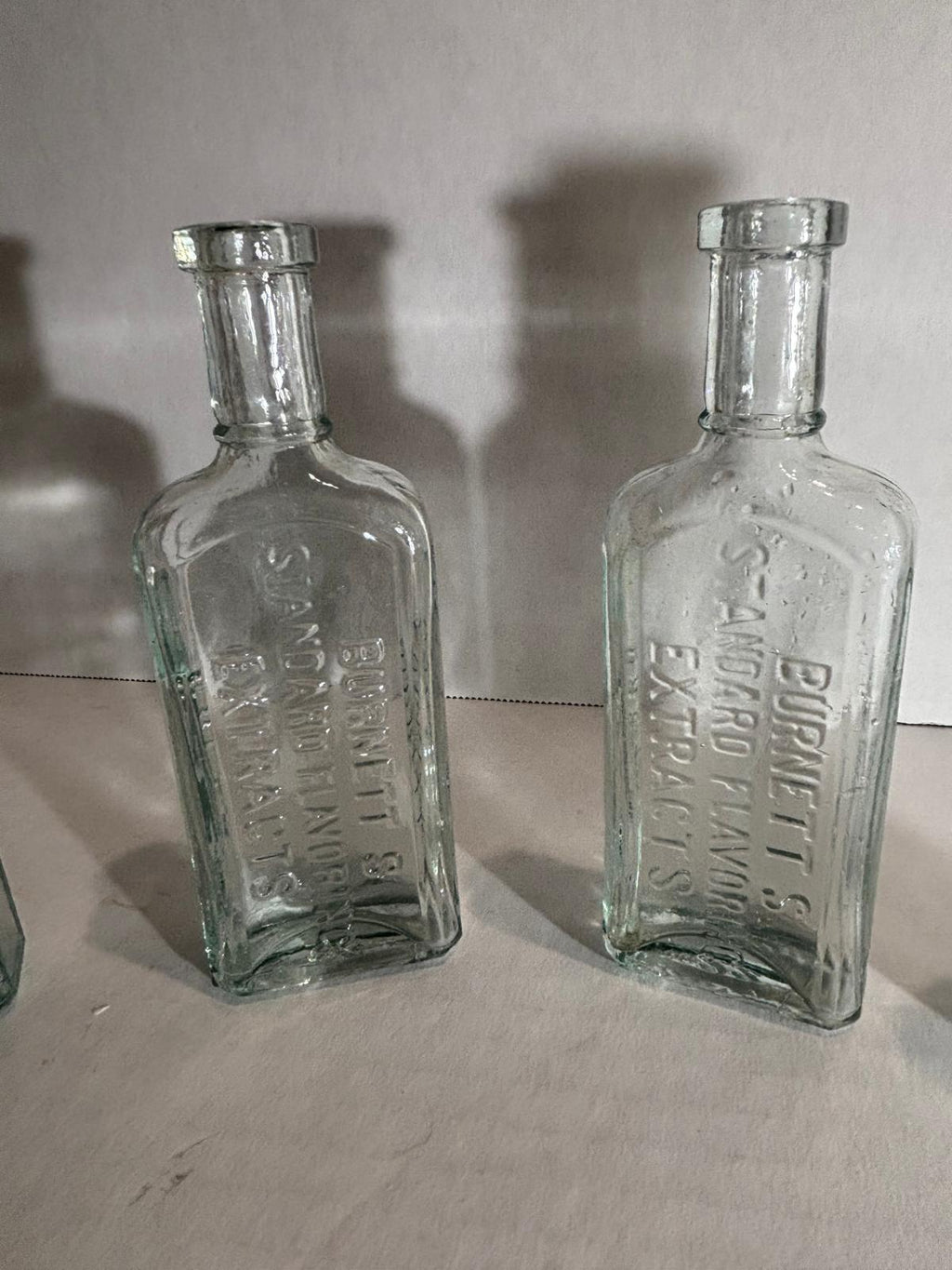Group of Six Burnett’s Standard Flavoring Extract Bottles, Boston, Late 19th Century