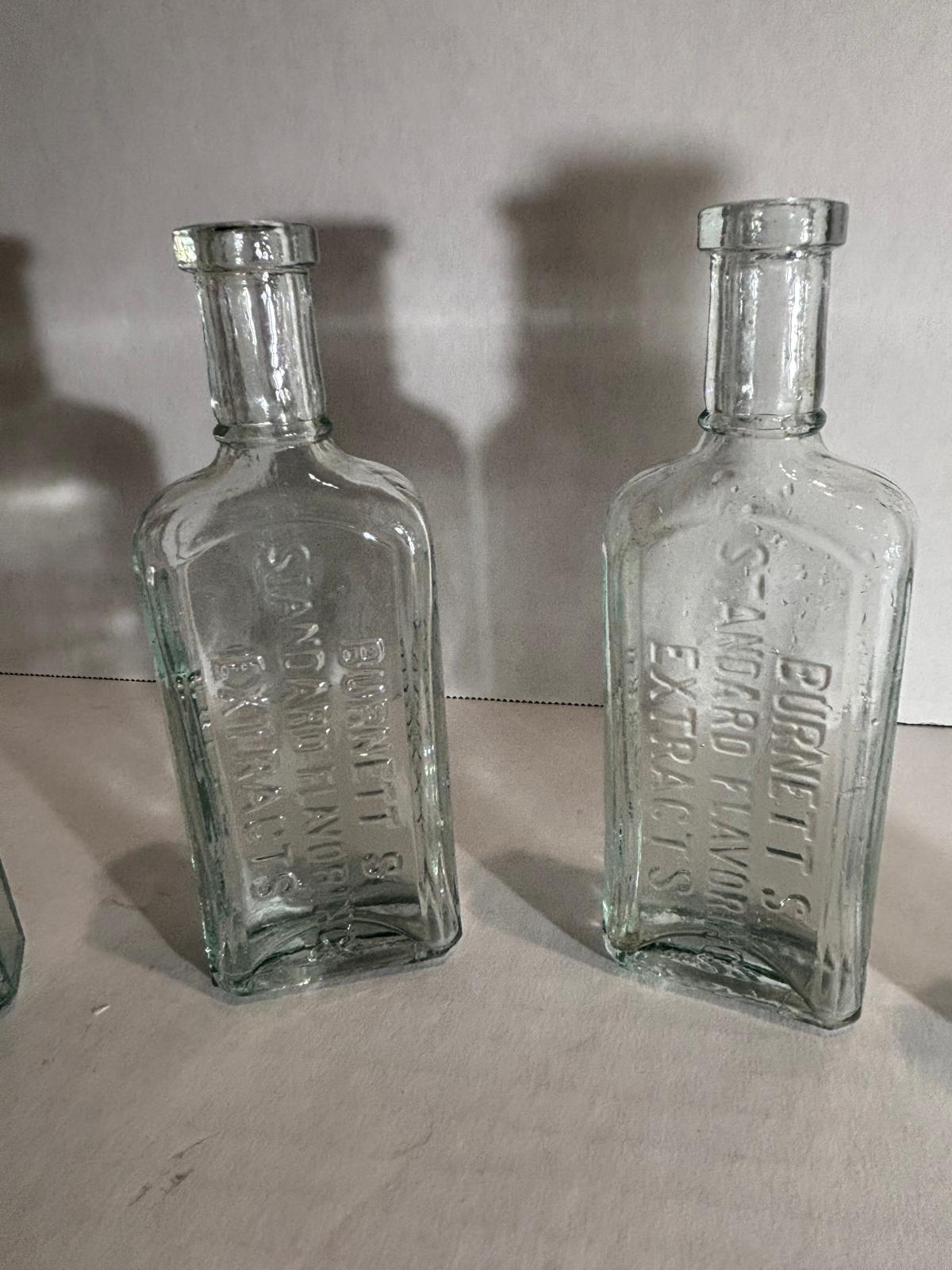 Group of Six Burnett’s Standard Flavoring Extract Bottles, Boston, Late 19th Century